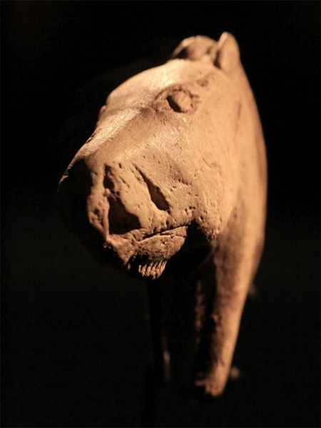 A primitive, probably ceramic, sculpture of a horse's head